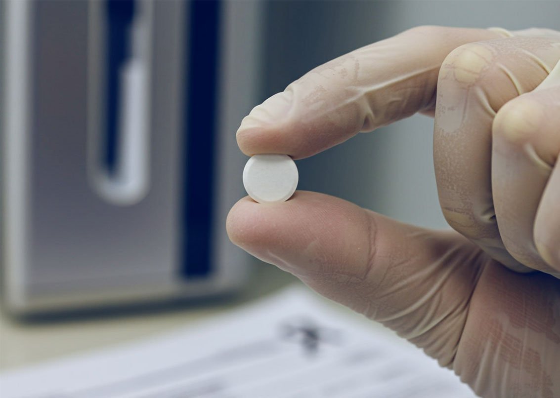 Врач держит таблетку